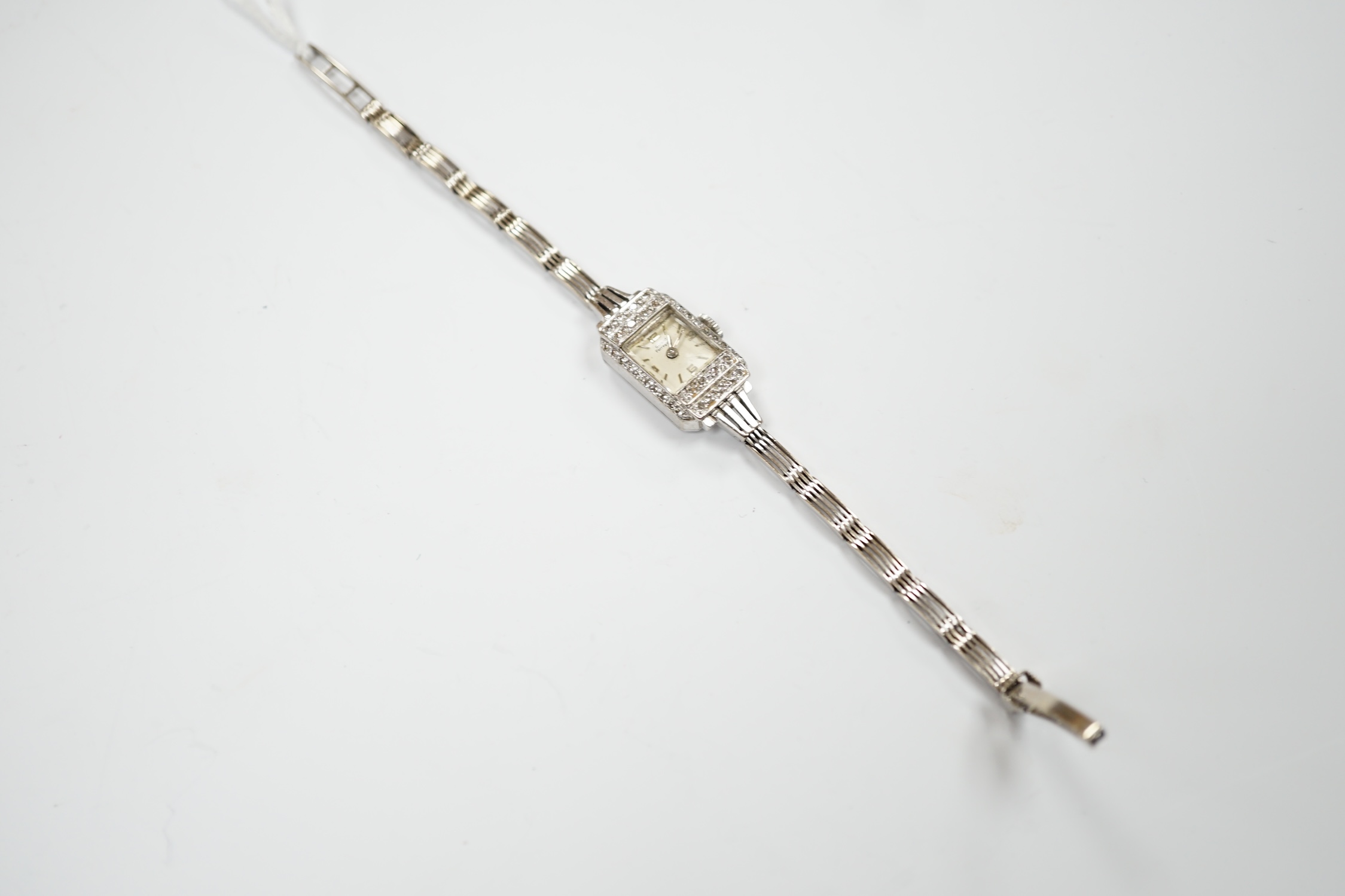 A lady's Girard Perregaux white metal and diamond cluster set manual wind cocktail watch, on a 9ct white gold bracelet, overall 16.5cm, gross weight 17.8 grams.